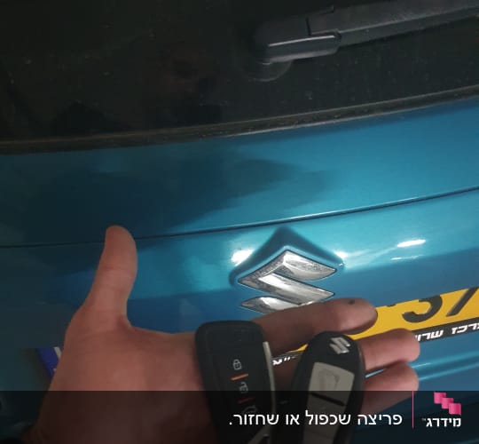מפתחות רכב ביד מול סמל סוזוקי